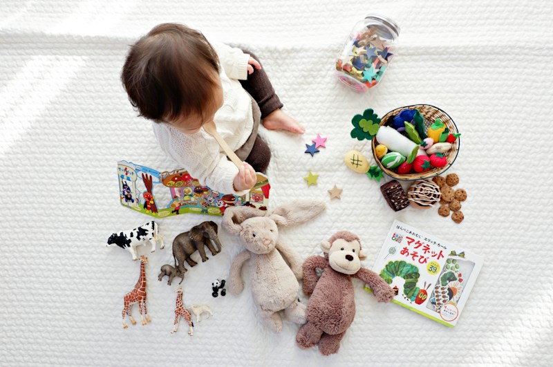 A little one exploring soft toys and picture books on a cozy blanket