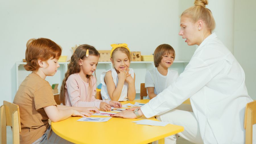 Young children making art together with their teacher